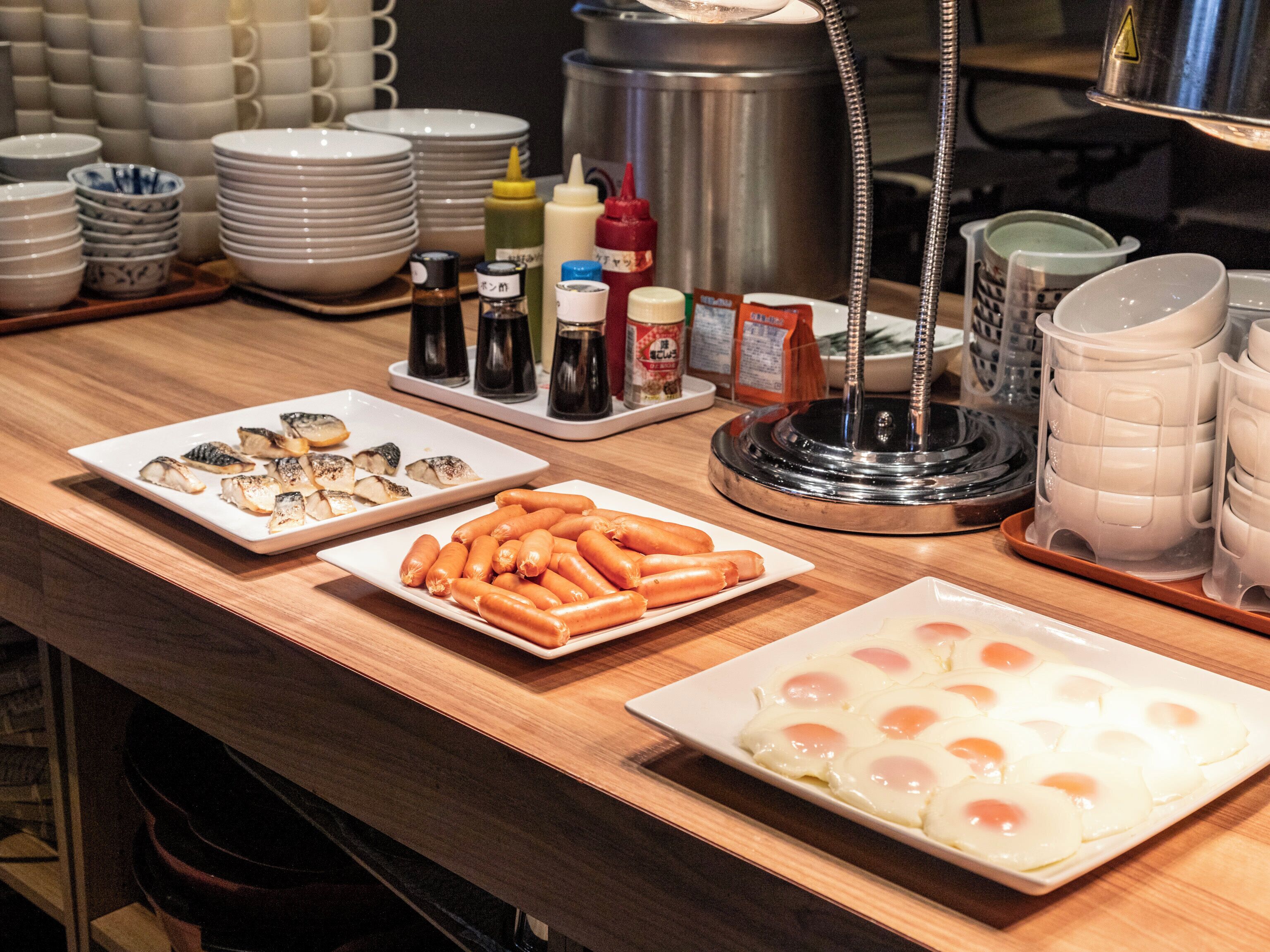 Una mesa de buffet con diversos alimentos y salsas.