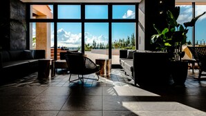 Un intérieur moderne avec une grande fenêtre donnant sur le ciel et les nuages.