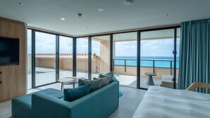 Une chambre d’hôtel moderne dotée d’un grand balcon, d’un canapé, d’un lit et d’une télévision.