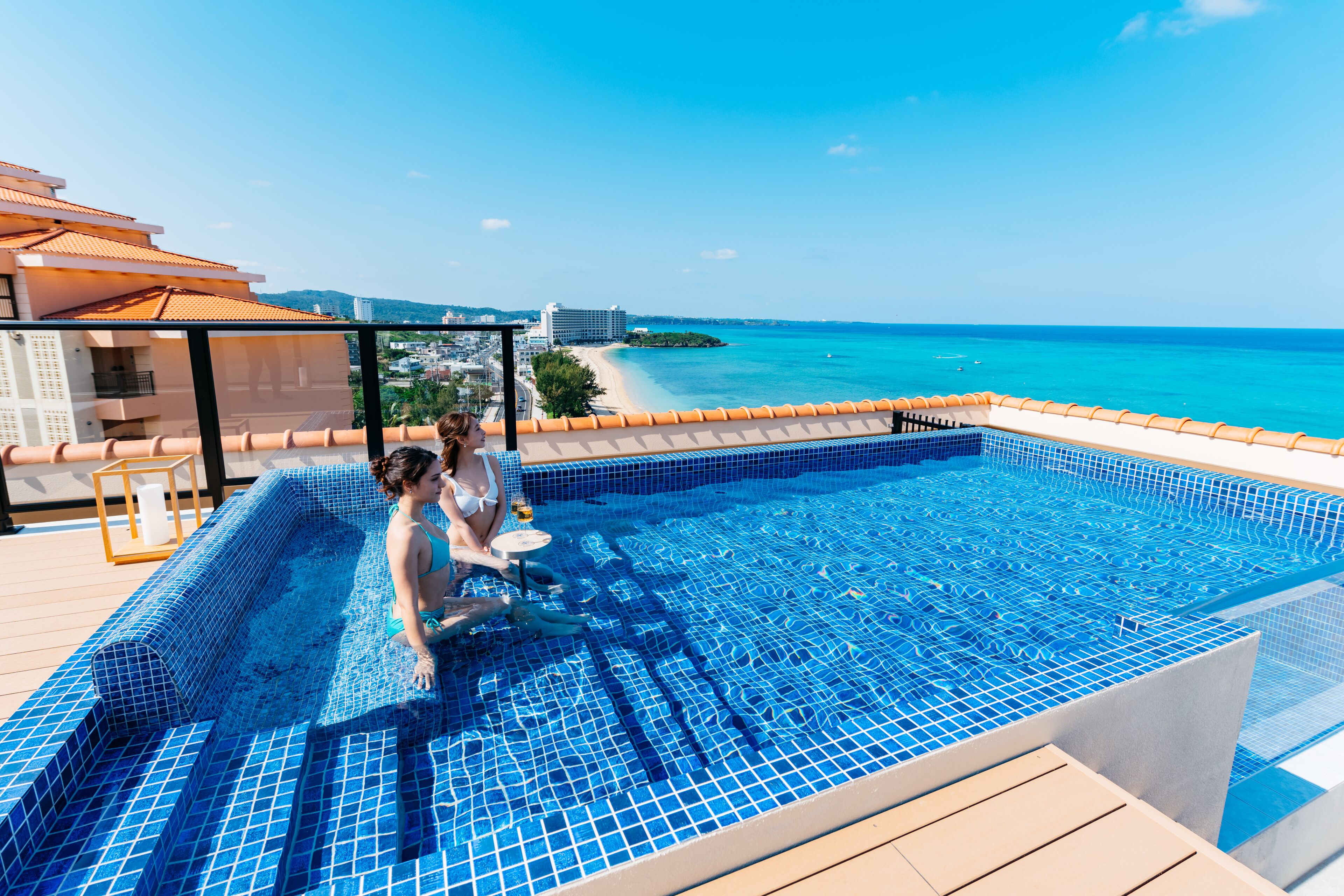 Una piscina en la azotea con vistas despejadas a la playa y al océano.