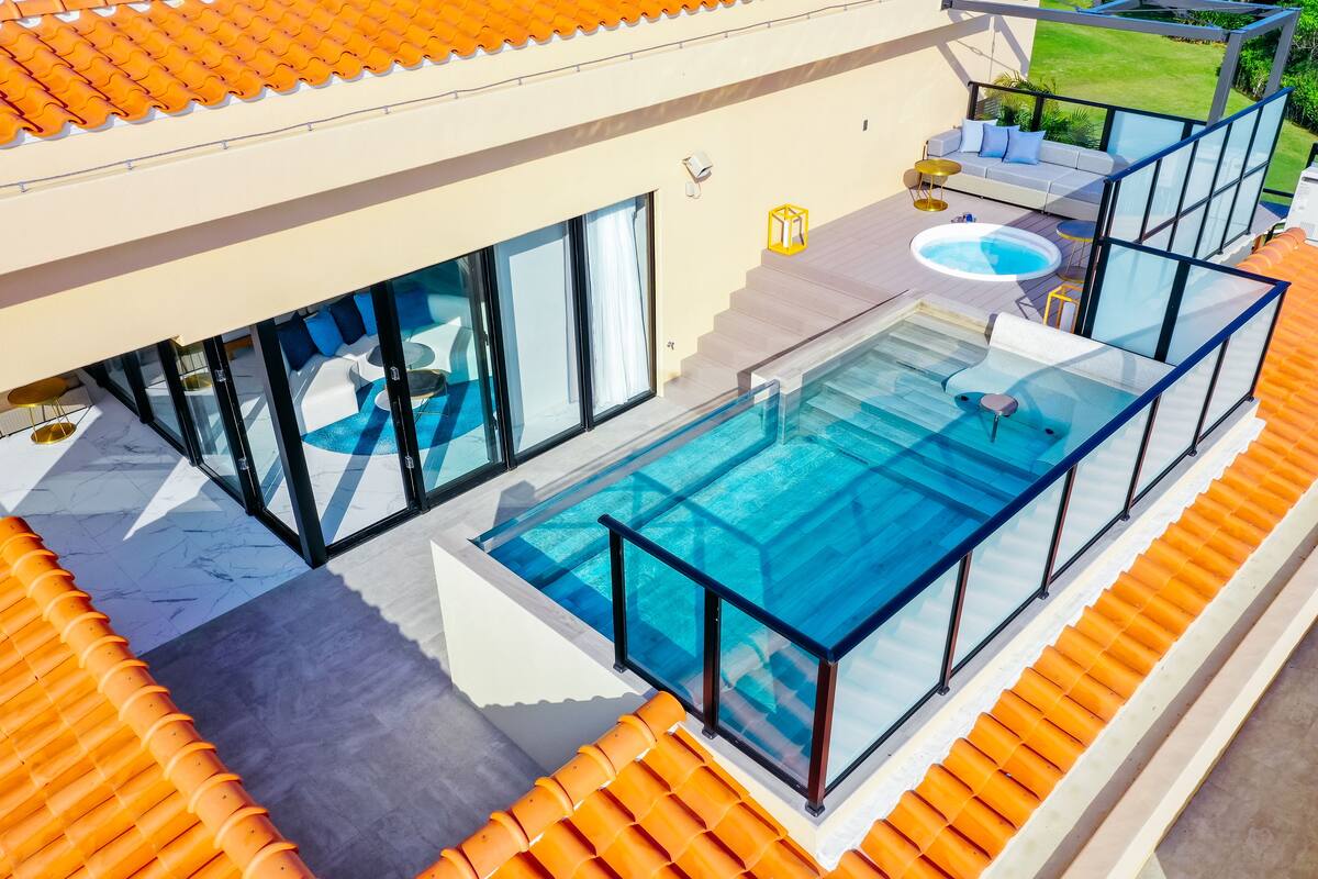 Uma casa moderna com piscina envidraçada, hidromassagem e terraço solar com área de estar ao ar livre.