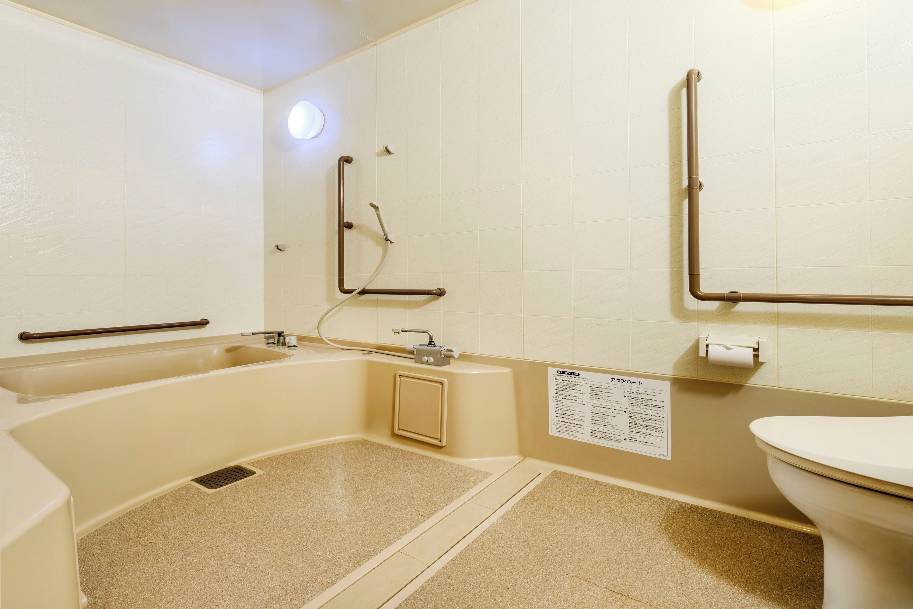 A bathroom with a bathtub, a toilet, and a shower area.