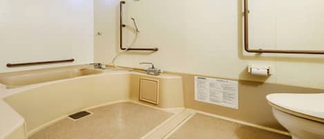 A bathroom with a bathtub, a toilet, and a shower area.