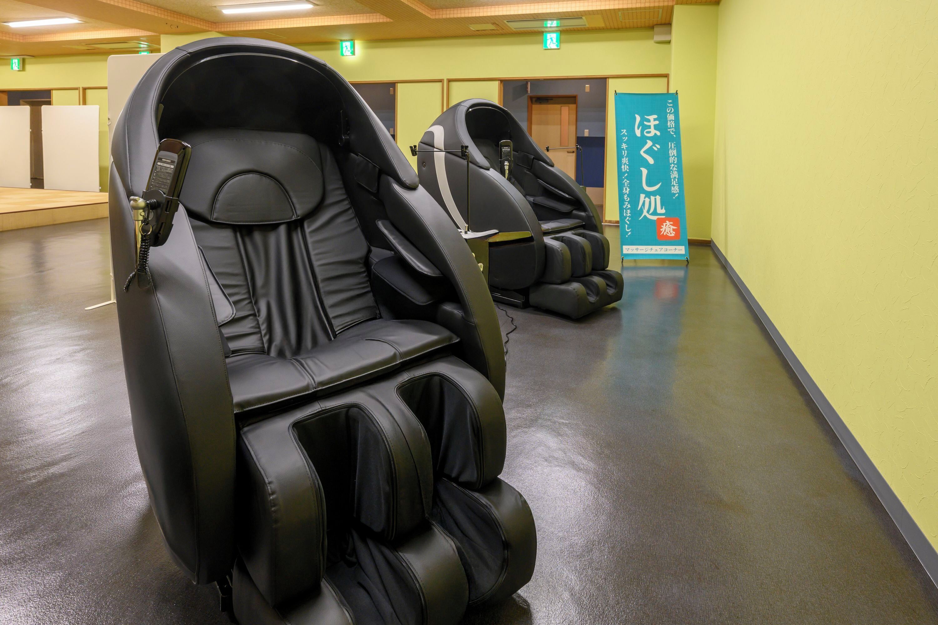 A massage chair area with multiple chairs and a promotional banner.