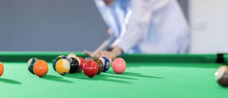 A pool table with balls and a person playing.