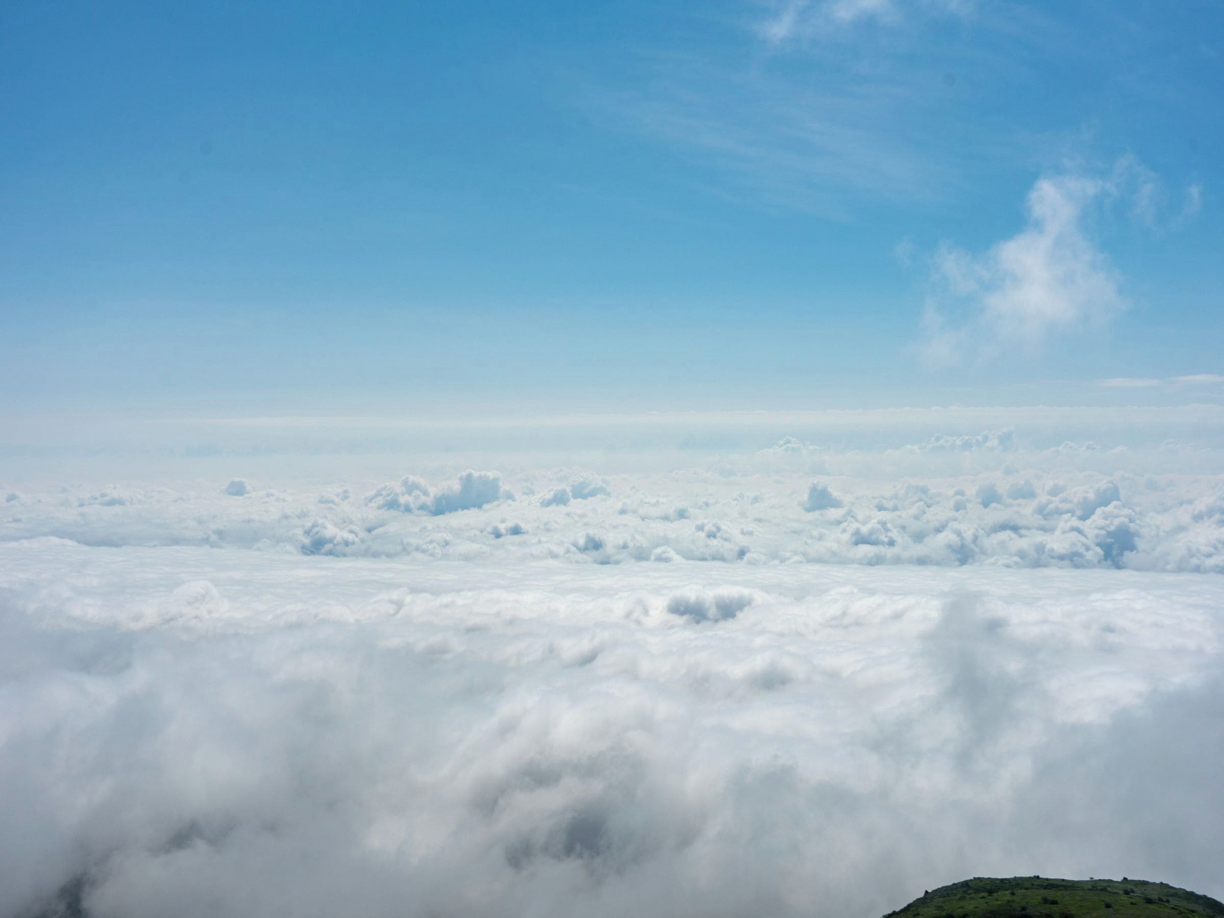 A view of a mountain range with a layer of clouds below.