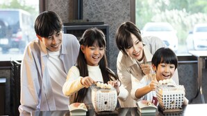 Una familia de cuatro personas en una mesa con juegos de té tradicionales japoneses.