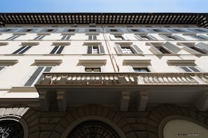 Un edifici amb nombroses finestres, un balcó amb barana i una galeria d'arc de pedra.