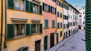 A narrow street lined with colorful buildings, each with multiple windows and doors, suggesting a residential area. - Wine Apartments Florence Sangiovese (Firenze)