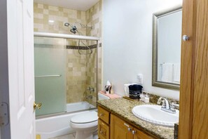 Une salle de bain équipée d’une douche, de toilettes, d’un lavabo et d’un meuble-lavabo.