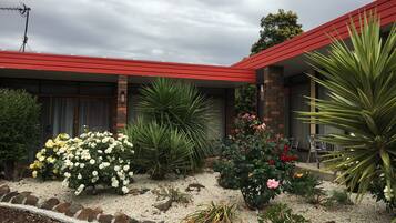 Set amidst a lush garden with a variety of plants, this charming building offers a serene atmosphere.
