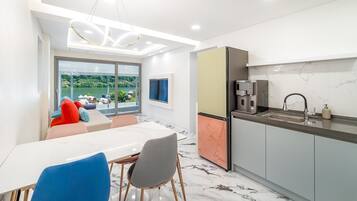 Una cocina moderna con cafetera integrada, un lavamanos y un comedor con mesa y sillas.
