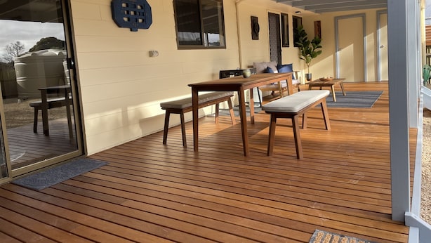 A covered patio with wooden flooring, a bench, a table, and a chair. - Minutes to the beach! Freshly renovated, stylish & modern. (Hardwicke Bay)