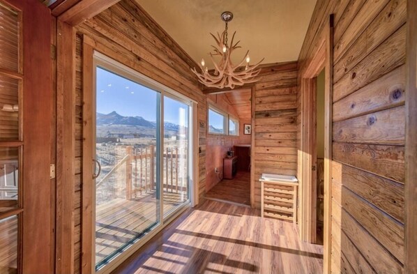 Enjoy a room with a high ceiling, large windows, and a chandelier, offering a view of the surrounding mountains.