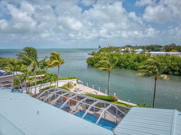 A pool area with a view of a tropical beach and ocean. - P45 - Spacious 5 bedroom, 5 bath home with spectacular open water views. (Marathon)