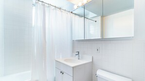 Ett modernt badrum med ett vitt handfat, en spegel och en toalett.