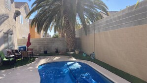 A backyard with a swimming pool, patio furniture, and potted plants. - Enjoy your stay in a clean, safe environment easy access to freeways (Las Vegas)