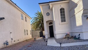 A building with a white facade, a black gate, and a palm tree. - Enjoy your stay in a clean, safe environment easy access to freeways (Las Vegas)