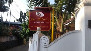 Indicador de Swasti Ghna Home Stay amb números de contacte.