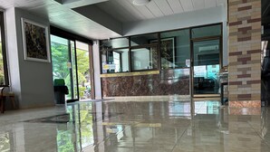 A spacious lobby with a polished marble floor, large windows, and a modern reception desk. - OKHOME HOSTEL (Bang Phli)