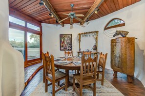 A dining area with a wooden table, chairs, and a rustic cabinet.