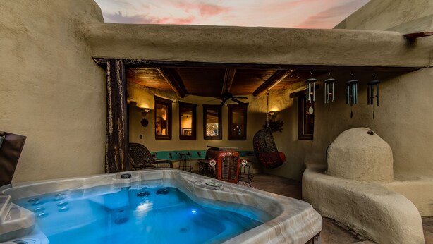 A hot tub in a rustic outdoor area with a ceiling and a chair. - Eclectic Santa Fe Ranch Home + Casita with Hot Tub in Cave Creek (Cave Creek)