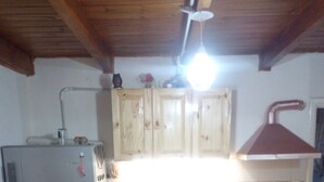 A kitchen with wooden cabinets, a refrigerator, a sink, and a stove. - Hostel Piltri  (El Bolson)