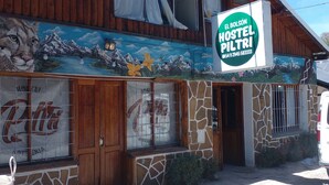 A hostel with a mural of a mountain landscape and a sign reading "El Bolson Hostel Piltri". - Hostel Piltri  (El Bolson)