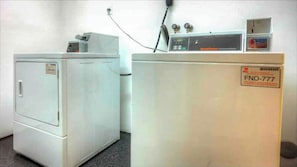 A laundry room with two washing machines and a commercial washer. - Gorgeous 1 bedroom with pool (Miami Beach)