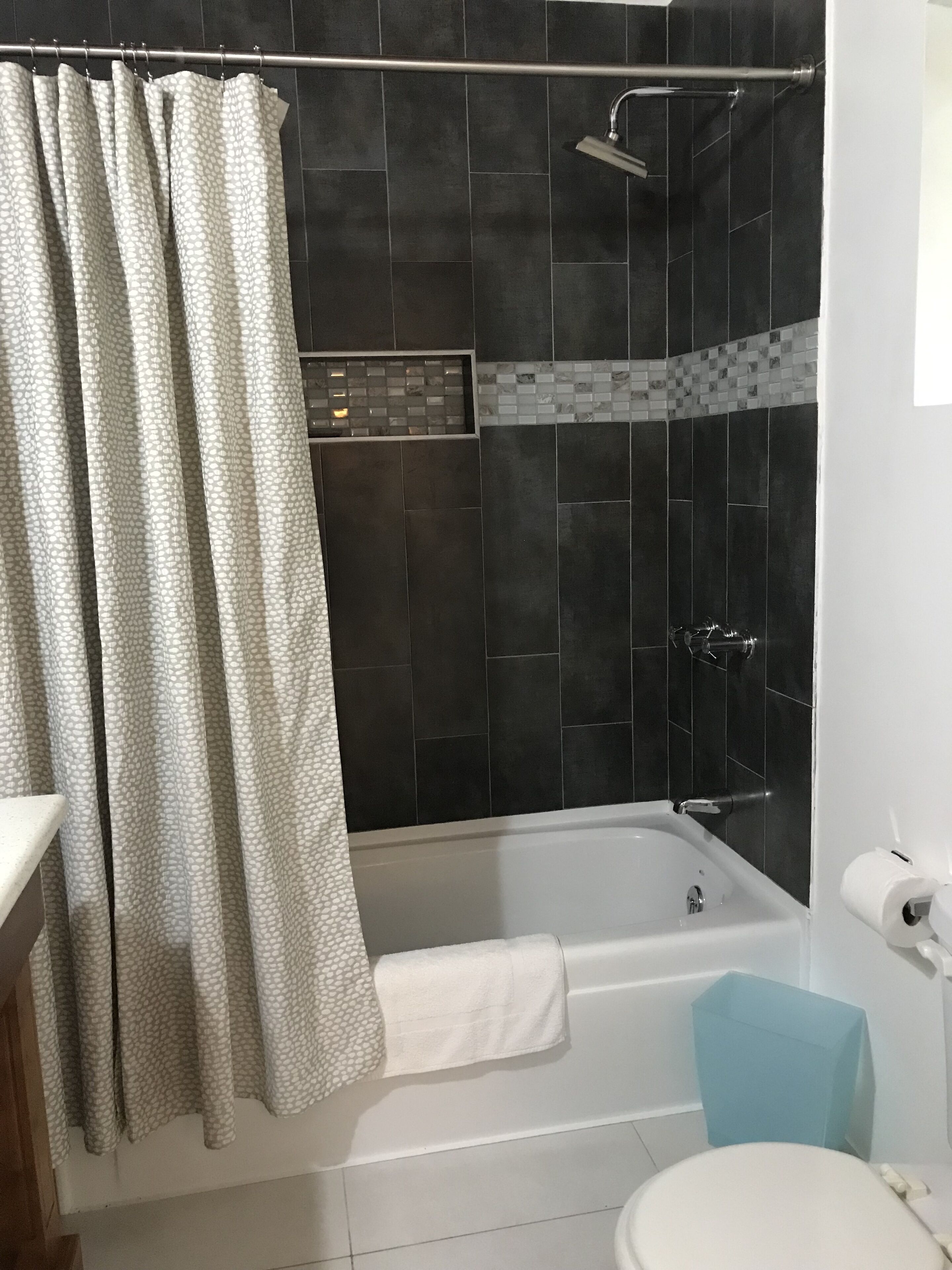 Un baño con bañera, ducha e inodoro.