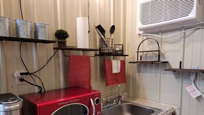 A compact kitchen with a red microwave, a sink, and a countertop. - City limits, off interstate I20 & west co rd WIFI (Odessa)