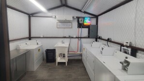 Un cuarto de lavandería con lavadora, secadora y un lavamanos pequeño.