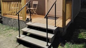 Una casita con porche, escalones y una puerta.