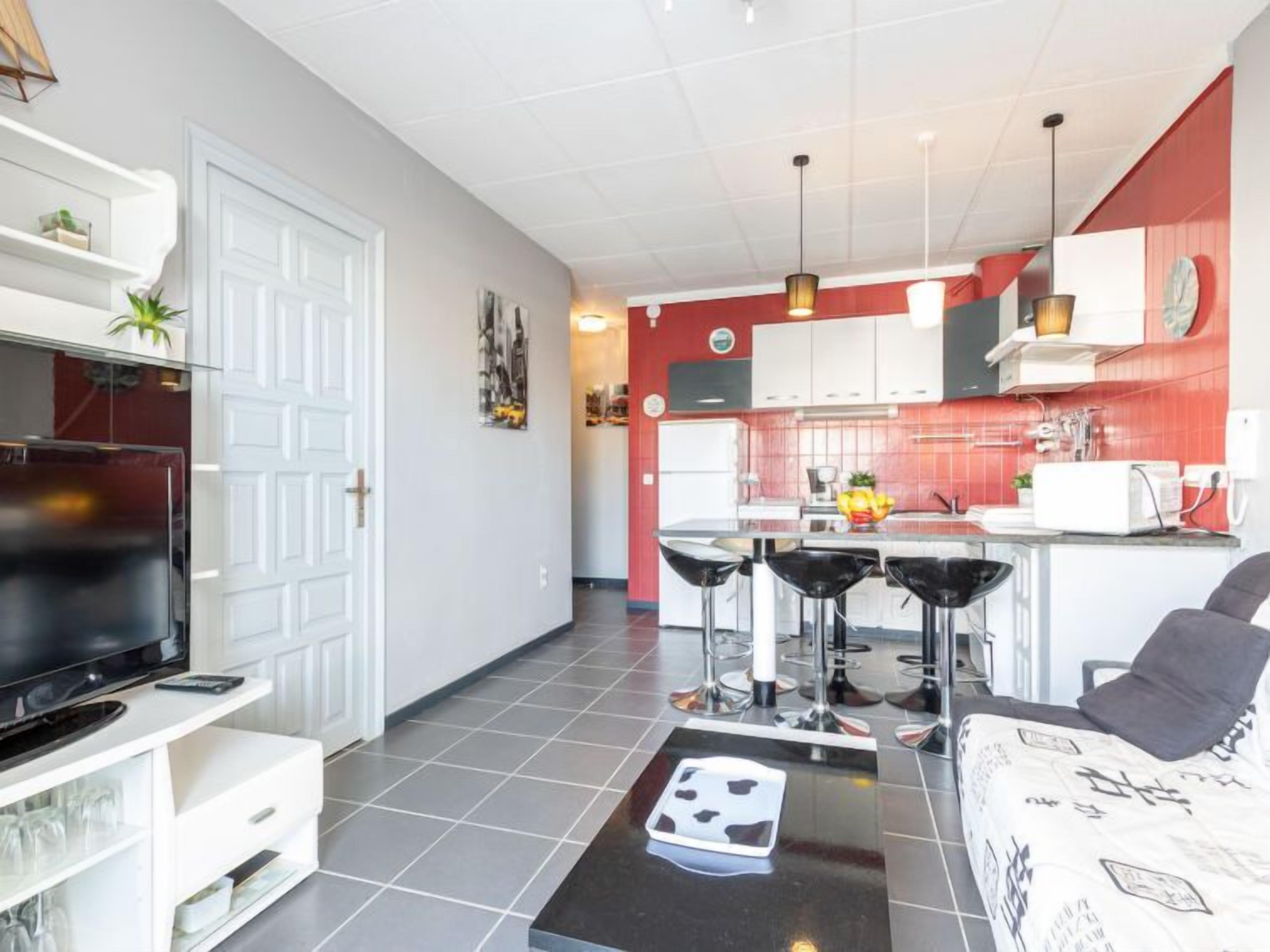 A modern apartment with a living room, kitchen, and dining area.