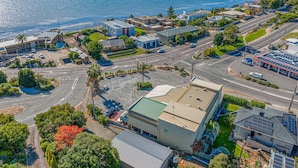 An aerial view of a coastal area with buildings, roads, and a marina. - Navigators Motel (Port Lincoln)