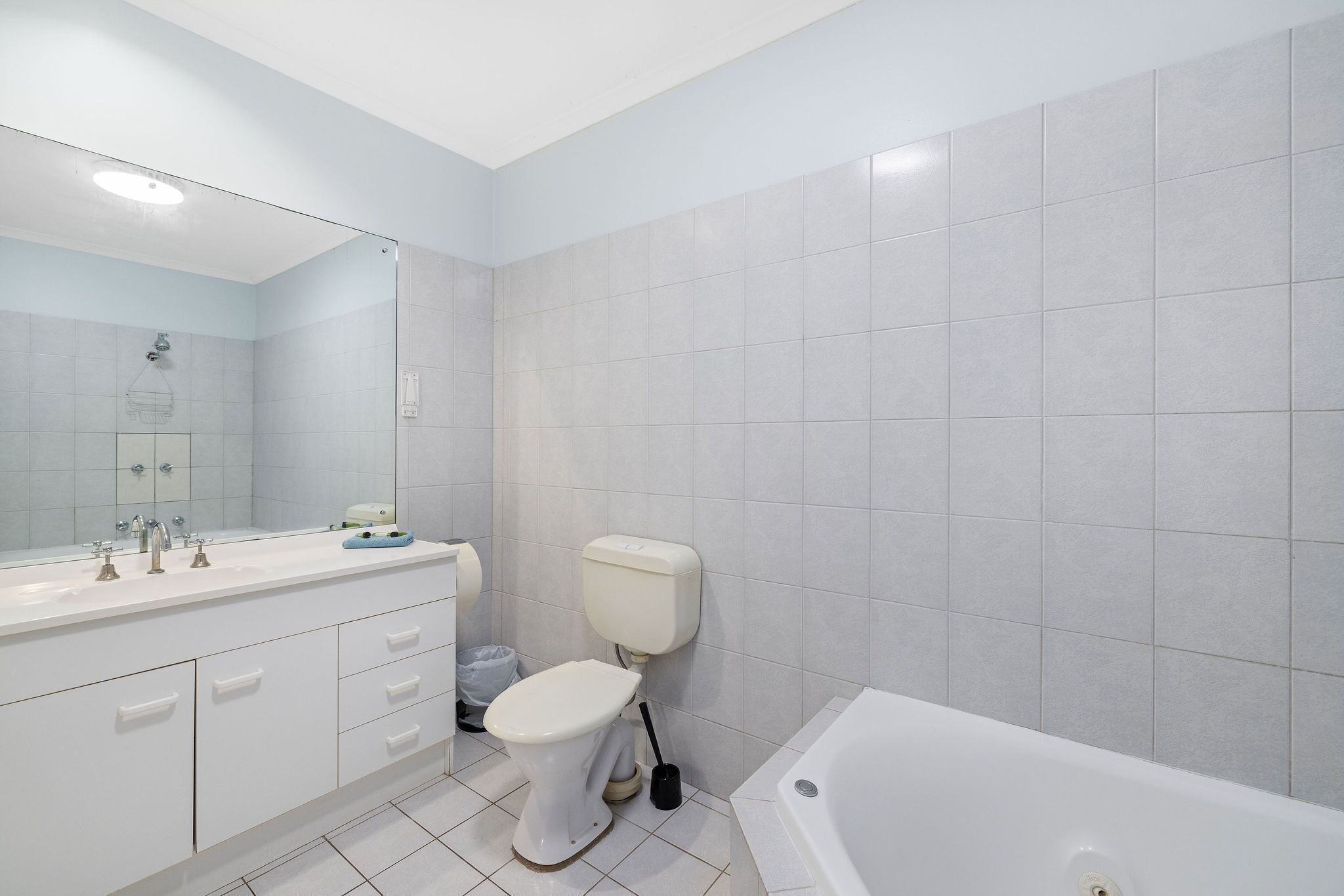 Un baño moderno con lavamanos, inodoro y bañera blancos.