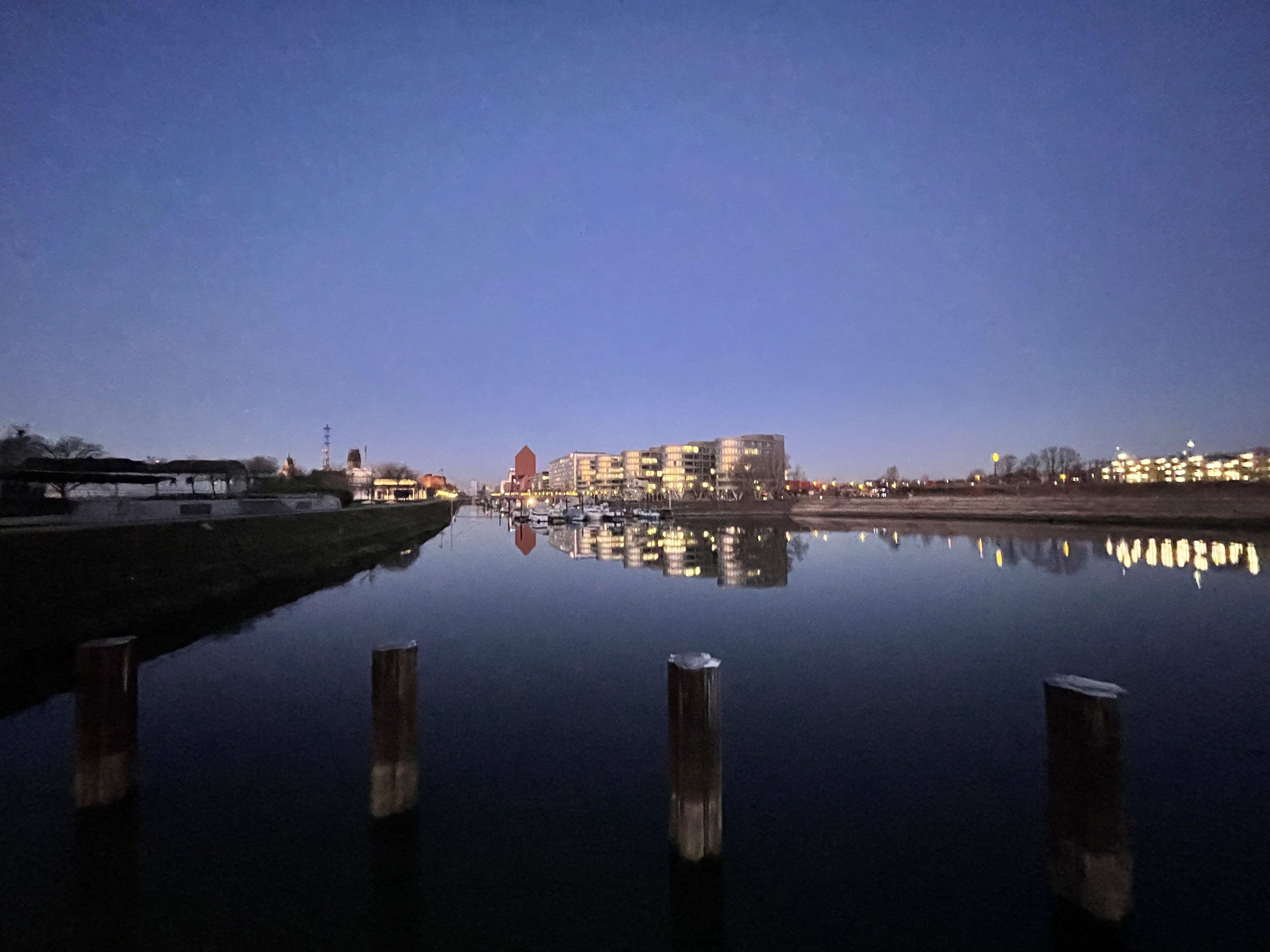 Un río tranquilo que refleja edificios y un puente.