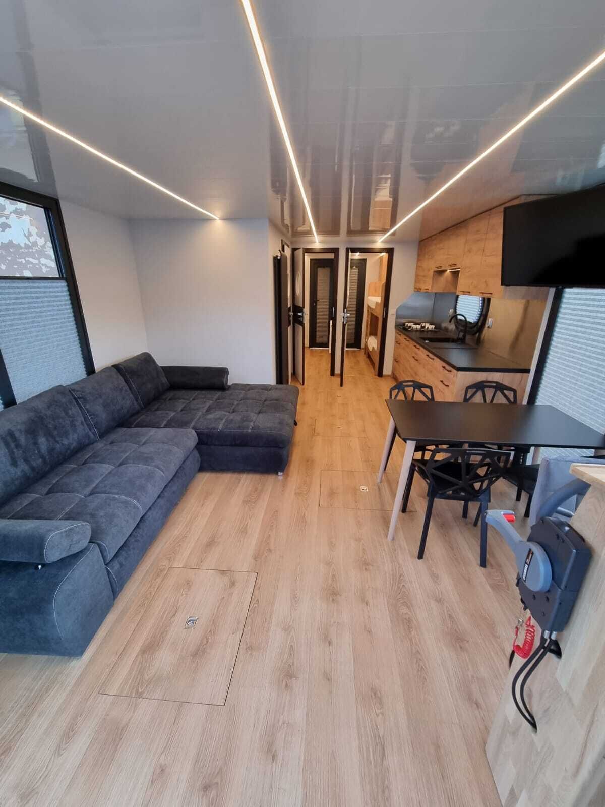 A compact living space with a sofa, a dining table with chairs, and a kitchen area.