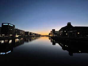 A calm river reflecting buildings at dusk. - Hausboot Lore (Duisburg)
