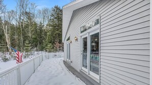 A building with a snow-covered porch and a white fence. - Cardinals Perch (Campton)