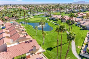 A residential area with houses, a golf course, and a pond. - Golf, Sun and Serenity: Your Relaxing Desert Escape Awaits! (Palm Desert)