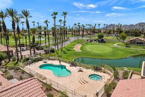 A golf course with a swimming pool and palm trees. - Golf, Sun and Serenity: Your Relaxing Desert Escape Awaits! (Palm Desert)