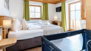 Een slaapkamer met een bed, bureau, televisie en een trampoline.