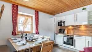 Een moderne keuken met witte kasten, een houten aanrechtblad en een inbouwoven.