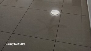 Un soggiorno moderno con televisore a schermo piatto, ventilatore a soffitto, divano e tavolino.
