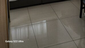 Una camera da letto con un letto, una ventola a soffitto, una finestra con tende e una sedia.