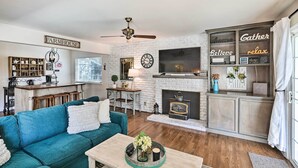 A cozy living room with a teal sofa, a fireplace, a television, and a coffee station. - 1 Mi to Main Street Sutter Creek: Poolside Oasis! (Sutter Creek)