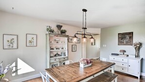 A dining area with a wooden table and benches, a white cabinet with dishes, and a hanging light fixture. - 1 Mi to Main Street Sutter Creek: Poolside Oasis! (Sutter Creek)
