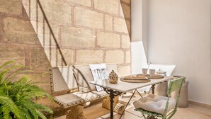 A stone wall, a table with a bench, a chair, and a potted plant. - Holiday Home 'Ca Na Francesca' with Mountain View, Wi-Fi and Air Conditioning (Pollença)