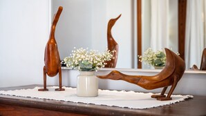 A wooden duck sculpture on a table with a vase of flowers. - Holiday Home 'Ca Na Francesca' with Mountain View, Wi-Fi and Air Conditioning (Pollença)